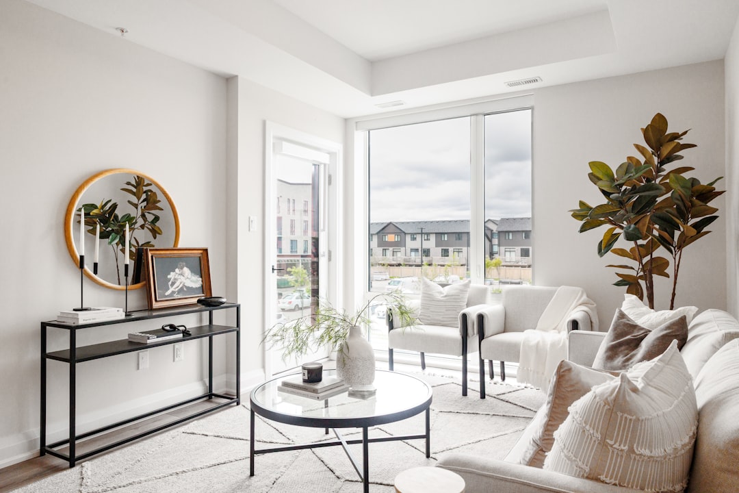 Modern living room with minimalist decor and large window.